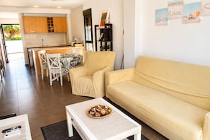 Ein Wohnzimmer mit einer Couch, einem Couchtisch und einem Essbereich mit Stühlen und einem Tisch.