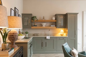 A kitchen with grey cabinets, a wooden countertop, and a chair. - Luxury Stratford-upon-Avon Apartment | Walk to RSC | Sleeps 2 (Stratford-upon-Avon)