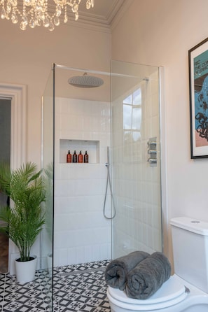 A bathroom with a glass-enclosed shower, a toilet, a potted plant, and a framed picture on the wall. - Luxury Stratford-upon-Avon Apartment | Walk to RSC | Sleeps 2 (Stratford-upon-Avon)