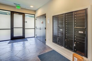A hallway with a metal mail drop, a door marked 'EXIT,' and a mat on the floor.