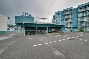 Ein Parkplatz mit einem Gebäude, das einen Balkon mit Geländern und eine Flagge hat.
