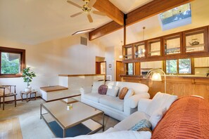 Ein modernes Wohnzimmer mit einer Couch, einem Couchtisch und einem Deckenventilator.