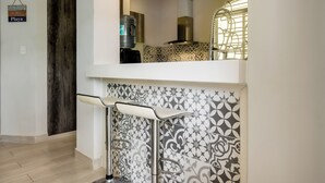 Cucina con dispenser d'acqua, cappa aspirante in acciaio inox e zoccolo decorato.