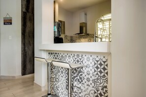 A kitchen with a water dispenser, a stainless steel range hood, and a patterned backsplash. - Modern Condo: Steps to Mamitas Beach Club/5thAve (Playa del Carmen)