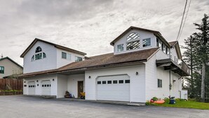Une maison à deux étages avec un garage, un porche à l’avant et une allée.