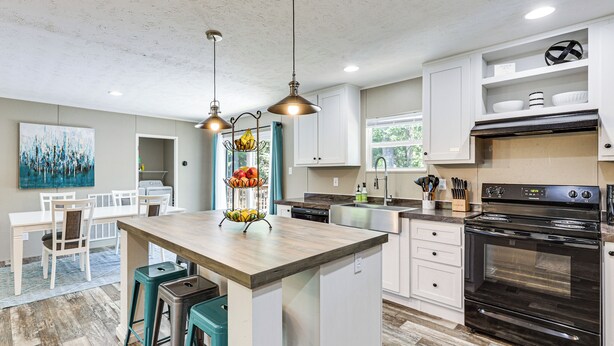 A modern kitchen with a central island, pendant lights, and a large oven. - It's Our Pleasure! Lake Escape w/ Boat Ramp (Macon)