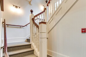 A staircase with a wooden handrail and white walls.