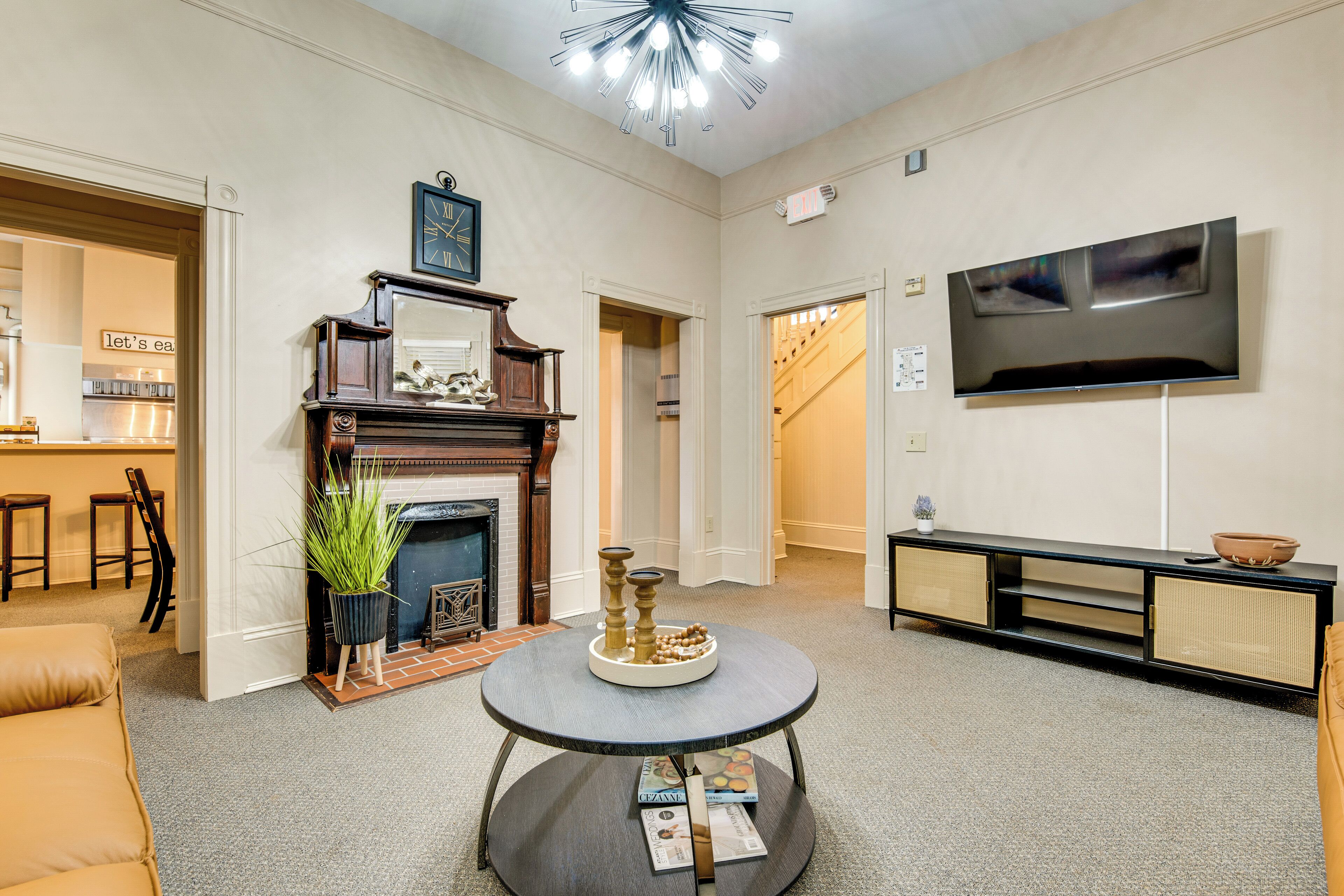 A living room with a fireplace, a round coffee table, a television, and a sofa.