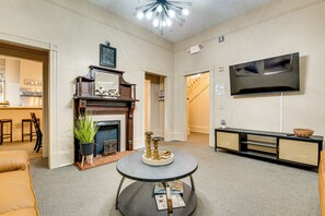 A living room with a fireplace, a round coffee table, a television, and a sofa.
