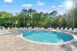 A swimming pool with lounge chairs and umbrellas, surrounded by trees. - Resort-Style Ocean Isle Beach Retreat w/ Pool (Shallotte)