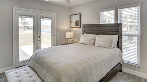 A bedroom with a bed, a ceiling fan, a nightstand with a lamp, and a window with blinds. - Grand Prix Energy 1 Mi From the Strip (Las Vegas)