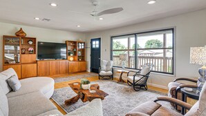 A living room with a sofa, chairs, a coffee table, a TV, and a bookshelf. - Elegant Waterfront Retreat w/ Dock in Dickinson (Dickinson)