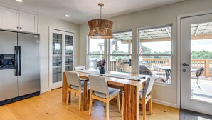 A modern kitchen with a dining area, wooden flooring, and large windows. - Elegant Waterfront Retreat w/ Dock in Dickinson (Dickinson)