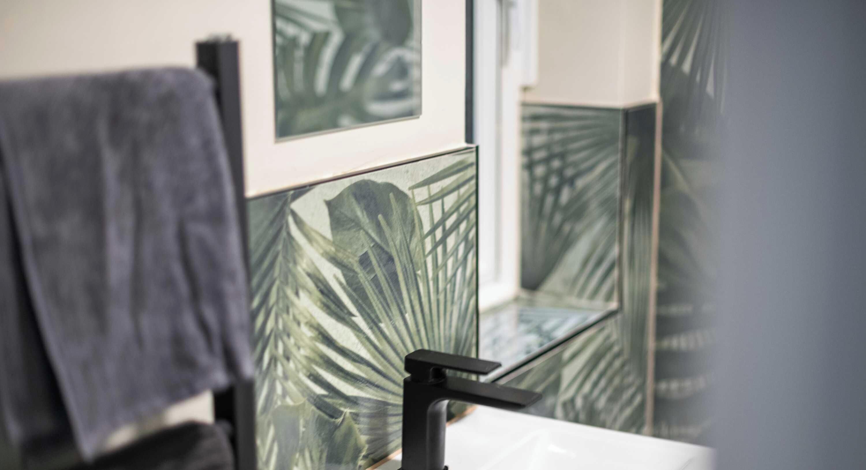 A bathroom with a mirror, a towel, and a sink.