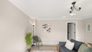 A living room with a sofa, a chair, a floor lamp, a painting, and a potted plant. - Flat 3, Franklin Apt Reading (Berkshire)