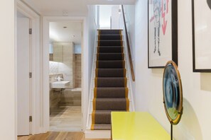 Eine Treppe mit Handlauf und einem gelben Tisch im Vordergrund.