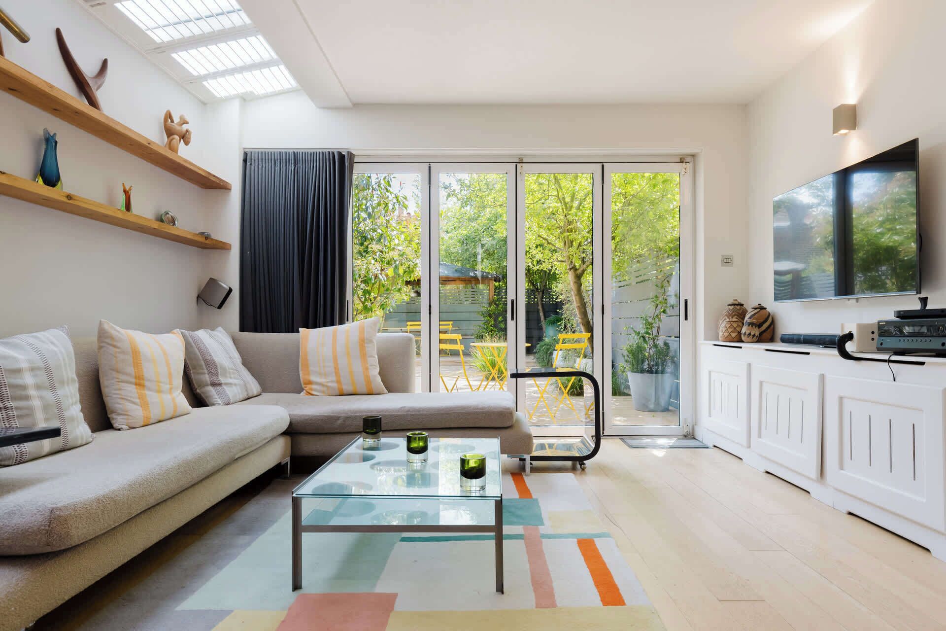 A modern living room with a sofa, glass coffee table, and a TV.