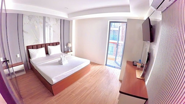 A modern hotel room with a large bed, a TV, a balcony, and a wooden floor. - The Crown Airport Hotel (Ho Chi Minh City)