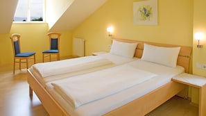 A room with two beds, a window, a chair, and a wall-mounted light fixture. - Apartment 'Säntis' with Sea View, Balcony and Wi-Fi (Wasserburg am Bodensee)