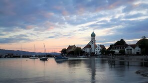 A waterfront town with boats, a church, and traditional buildings. - Apartment 'Säntis' with Sea View, Balcony and Wi-Fi (Wasserburg am Bodensee)
