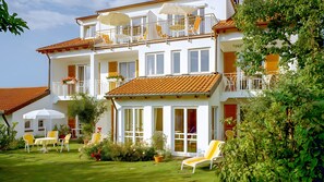 A two-story building with balconies, outdoor seating, and a well-maintained garden. - Apartment 'Säntis' with Sea View, Balcony and Wi-Fi (Wasserburg am Bodensee)