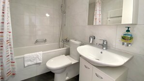 Un baño con bañera, inodoro y lavabo.