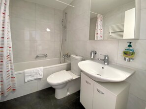 Ein Badezimmer mit Badewanne, Toilette und Waschbecken.
