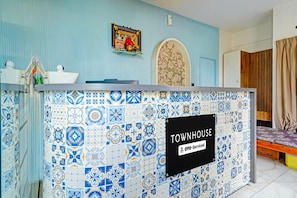 A reception desk with a 'TOWNHOUSE' sign, a patterned wall, and a door with a floral design.