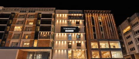 A multi-story building with a sign reading 'TOWNHOUSE' and 'YOYO-Serviced.'