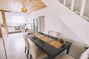 A dining area with a black table, white chairs, and a woven placemat. - Bildstein's "Kathmandu" (Langenfeld, Deutschland)