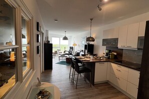 Eine moderne Küche mit Essbereich, Holzboden und Blick ins Freie.