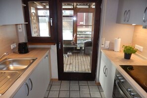 A kitchen with a sink, stove, and cabinets.