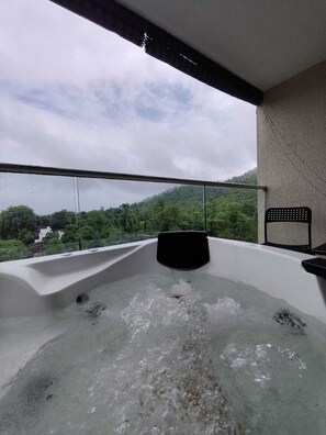 A hot tub with a view of a green landscape. - Chillout space-Palghar with private JACUZZI! (Velgaon)