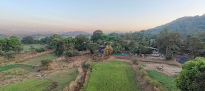A rural landscape with fields, trees, and scattered buildings. - Chillout space-Palghar with private JACUZZI! (Velgaon)