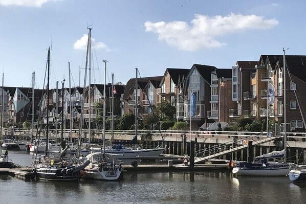A marina with multiple boats docked, a bridge, and residential buildings in the background. - 4 in the Weser I building (Cuxhaven-Döse)