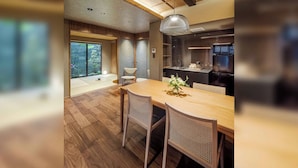 Una cocina moderna con un refrigerador negro, armarios de madera y un comedor con mesa y sillas de madera.