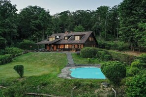 A house with a swimming pool, surrounded by a well-maintained garden and trees. - Gommerscheid Hunting Lodge (Ehlscheid)