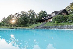 A house with a swimming pool, surrounded by greenery and a clear sky. - Gommerscheid Hunting Lodge (Ehlscheid)