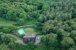 An aerial view of a property with a swimming pool, a small building, and a car parked nearby. - Gommerscheid Hunting Lodge (Ehlscheid)