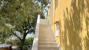 A staircase leading up to a building with a yellow exterior wall. - Apartments Vicelić (Orebic)