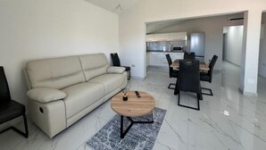 Una sala de estar moderna con un sofá, una mesa de centro y un comedor con sillas y una mesa.