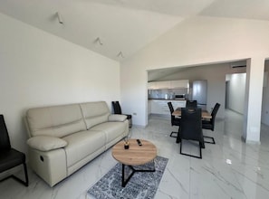 Una sala de estar moderna con un sofá, una mesa de centro y un comedor con sillas y una mesa.