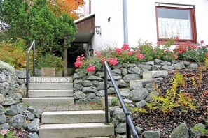 A stone staircase leading to a white building with a window and a door. - Holiday home with 2 bedrooms (Olsberg- Bruchhausen)