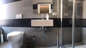 A modern bathroom with a toilet, sink, and glass shower enclosure. - Economy Room for 1  2 people Piazza San Giovanni (ROMA)