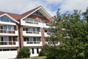A multi-story residential building with balconies, brick facade, and a clear sky. - 348 in the Trafalgar House (Cuxhaven - Döse)