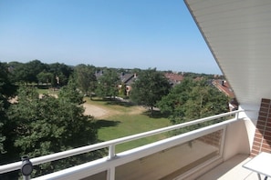 A balcony with a view of a residential area, including houses and trees. - 348 in the Trafalgar House (Cuxhaven - Döse)
