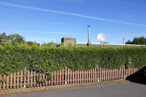 Ein eingezäuntes Gelände mit einem Gebäude, einer Satellitenschüssel und einem Schornstein.