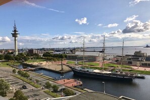 Ein großes Schiff liegt im Hafen, im Hintergrund ist ein Turm zu sehen.