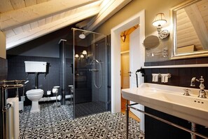 Ein Badezimmer mit Dusche, Toilette, Waschbecken und Spiegel.