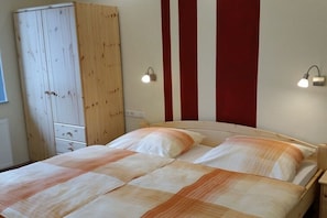 Ein Schlafzimmer mit einem Bett, einem Kleiderschrank und zwei Wandleuchten.